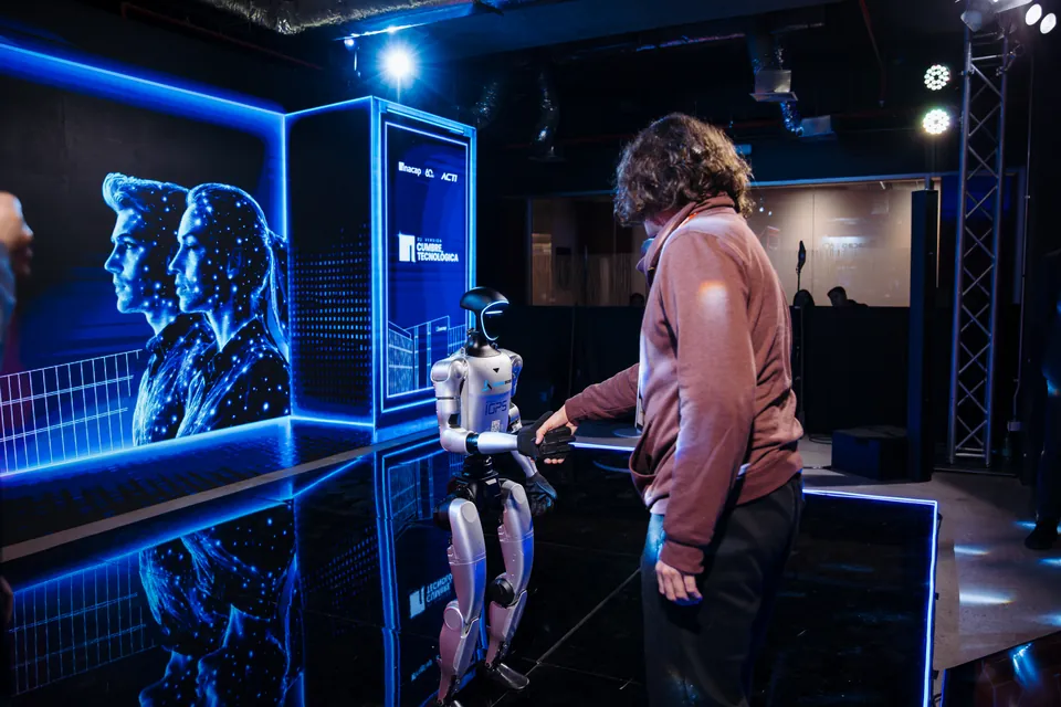 Un asistente interact&uacute;a con el robot humanoide G1